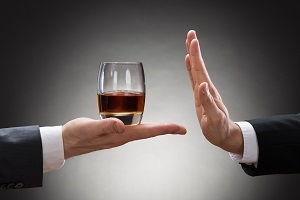 Businessman Rejecting Whisky Offered By Businessperson